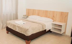 Schlafzimmer mit einem Bett mit einem Kopfteil aus Holz in der Unterkunft Casa LOURDES in Valledupar