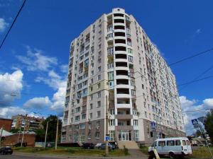 a tall building with a van parked in front of it at Studio with an amazing view - 15th floor in Kharkiv