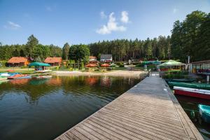 un molo con diverse barche su un lago alberato di Letnisko Zalesie a Rentyny