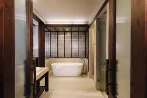 ein Badezimmer mit einer weißen Badewanne und einem Waschbecken in der Unterkunft T Heritage Hotel in Chiang Mai