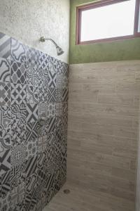La salle de bains est pourvue d'une douche avec une porte en verre. dans l'établissement Hacienda Gamboa, à Atlixco
