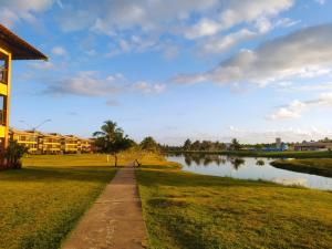 einen Weg neben einem See in einem Park in der Unterkunft Condomínio Villa das água, praia do saco in Estância