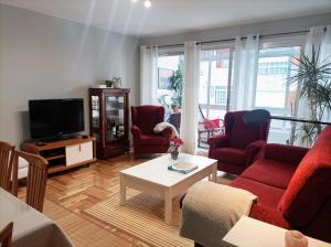 un soggiorno con divano, sedie e TV di Casa Porto, con Garaje a Vigo