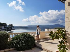 a woman standing on a balcony overlooking the water at Pontus Luxury Apartments in Tivat