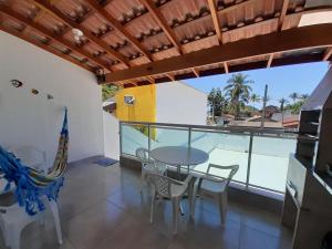 a dining room with a table and chairs on a balcony at A VER O MAR FLATS in Caraguatatuba