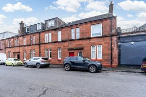 a brick building with cars parked in front of it at The Garden Flat, Loch Lomond in Alexandria