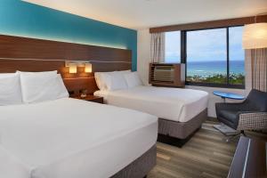 a hotel room with two beds and a window at Holiday Inn Express Waikiki, an IHG Hotel in Honolulu