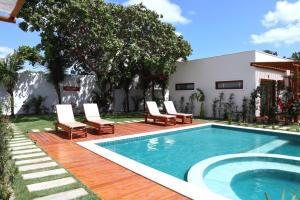 uma piscina com espreguiçadeiras ao lado de uma casa em Kai'ala Pousada em São Miguel do Gostoso