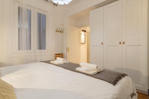 a white bedroom with a large bed with two towels on it at Bilbao Heart 2BDR Apartment - Parking opcional in Bilbao