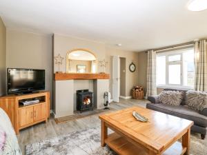 a living room with a couch and a fireplace at White Hillocks Cottage in Inchmill