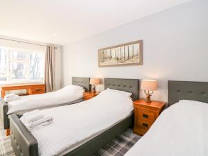 une chambre avec deux lits et deux lampes et une fenêtre dans l'établissement White Hillocks Cottage, à Inchmill