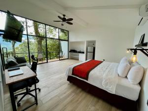 a bedroom with a bed and a desk with a desk at Sangregado Lodge in Fortuna