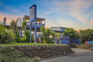 un bâtiment avec un panneau devant lui dans l'établissement The Great Ocean Road Studios, à Port Campbell
