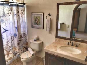 a bathroom with a toilet and a sink and a mirror at Gorgeous Beachfront Villa Rocky point, Sandy Beach in Puerto Peñasco