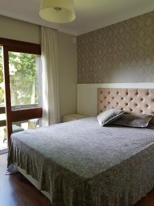 - une chambre avec un grand lit et une fenêtre dans l'établissement APARTAMENTO DO LAGO NEGRO, à Gramado