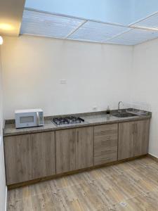 a kitchen with a sink and a microwave on a counter at Habitaciones tipo hotel con terraza in Ibagué