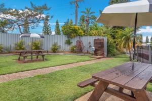 a picnic table and an umbrella in a yard at Lifestyle Villages Redhead in Redhead