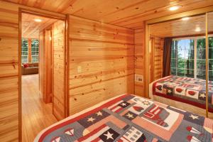Blockhausschlafzimmer mit 2 Betten und einem Fenster in der Unterkunft Racoon Retreat in Eastsound