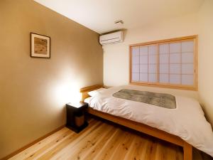 a small bedroom with a bed and a window at Aya inn Karasuma gojo in Kyoto