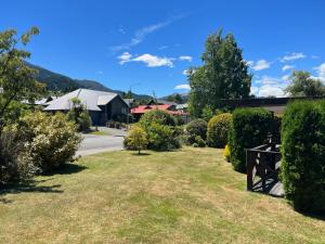 Un patio con arbustos y un camino con casas. en 23 St James Avenue, en Hanmer Springs