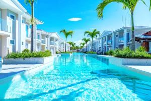 uma piscina com palmeiras e edifícios em RESIDENCIAL MONTE DAS OLIVEIRAS - Arraial D'Ajuda - Porto Seg - Ba - Alto da Pitinga - Casa Premium - Casa Buriti em Porto Seguro