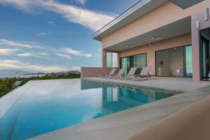 a villa with a swimming pool and a house at Michael villa in Koh Samui