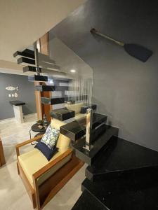 ein Wohnzimmer mit einer Treppe mit einem Sofa und einer Treppe in der Unterkunft RESIDENCIAL MONTE DAS OLIVEIRAS - Arraial D'Ajuda - Porto Seg - Ba - Alto da Pitinga - Casa Premium - Casa Buriti in Porto Seguro