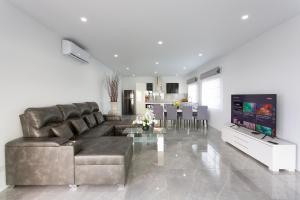 a living room with a leather couch and a television at Michael villa in Koh Samui