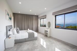 a white bedroom with a bed and a large window at Michael villa in Koh Samui +33 photos