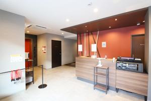 a kitchen with orange walls and a counter top at M's Hotel Nijojo Oike in Kyoto