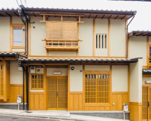 京都市にある香柏 金閣 福 - Kouhaku Kinkaku Fuku, Kyoto Machiyaの木製のドアと窓のある建物