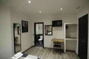 Habitación con cama, escritorio y aseo. en Hostal MH Fuencarral, en Madrid