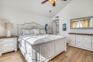 ein weißes Schlafzimmer mit einem Bett und einem Deckenventilator in der Unterkunft Villa De Montana in El Paso