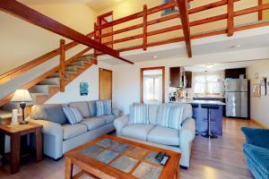 a living room with two couches and a table at Wooded Oasis in Edgartown