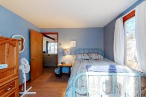 Schlafzimmer mit blauen Wänden, einem Bett und einem Schreibtisch in der Unterkunft Wooded Oasis in Edgartown
