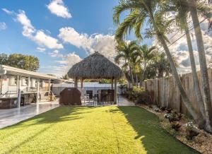 einen Hinterhof mit einem Rasenhof mit einem Pavillon in der Unterkunft Tiki-home Elite Staycation in Fort Lauderdale