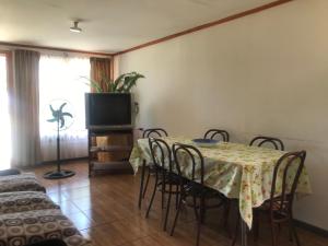a dining room with a table and chairs and a television at Cabaña en San Javier de Loncomilla, in Linares