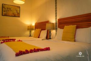 a hotel room with two beds with red flowers on them at Hotel Casa del Sol in San Cristóbal de Las Casas