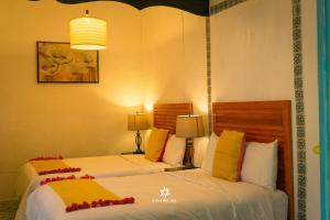- deux lits assis l'un à côté de l'autre dans une pièce dans l'établissement Hotel Casa del Sol, à San Cristóbal de Las Casas