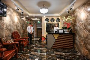 胡志明市的住宿－My Hotel，站在大堂的领带上,站在酒吧旁的男人
