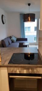 cocina con fogones horno de arriba junto a un sofá en Cozy City Apartment, en Düsseldorf