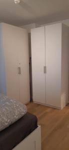 1 dormitorio con 2 armarios blancos y 1 cama en Cozy City Apartment, en Düsseldorf