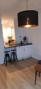 cocina con encimera y taburetes en una habitación en Cozy City Apartment, en Düsseldorf
