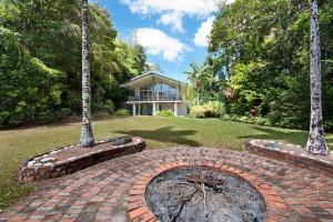 a brick path in front of a house with trees at Private Rainforest Ridge Retreat in Kuranda