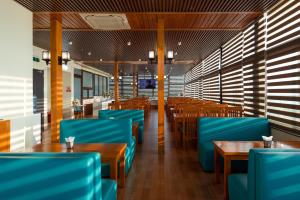 a dining room with blue chairs and tables at Stellar Hotel in Phú Quốc