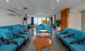 a waiting room with blue chairs and tables at Stellar Hotel in Phu Quoc