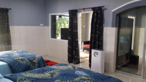 a bedroom with two beds and a window with curtains at Kuntum Cottage Bed & Breakfast in Kampong Tanjong Ipoh