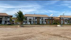 a palm tree in front of a row of houses at Brisas do Lago II in Paulo Afonso