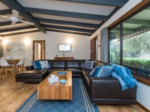 een woonkamer met een leren bank en een tafel bij Inlet Dreaming in Inverloch