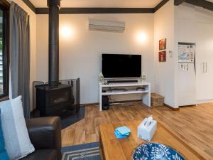 a living room with a television and a fireplace at Inlet Dreaming Free Wifi in Inverloch